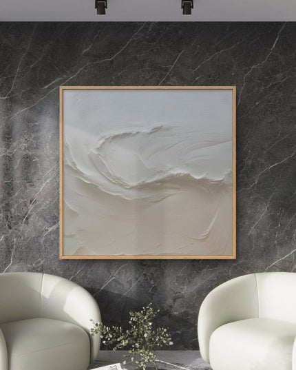 Modern living room with two white armchairs and a abstract painting on a marble wall.