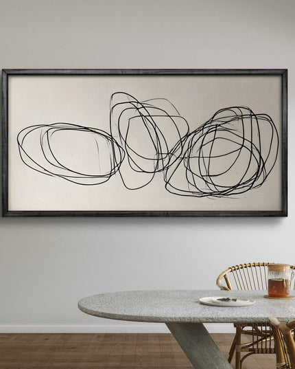 Abstract wall art with black lines on a beige background in a dining room setting.