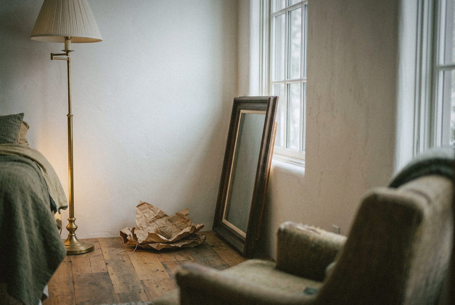 A framed painting leaning against a wall in a sitting room of a second home on a bright early February morning