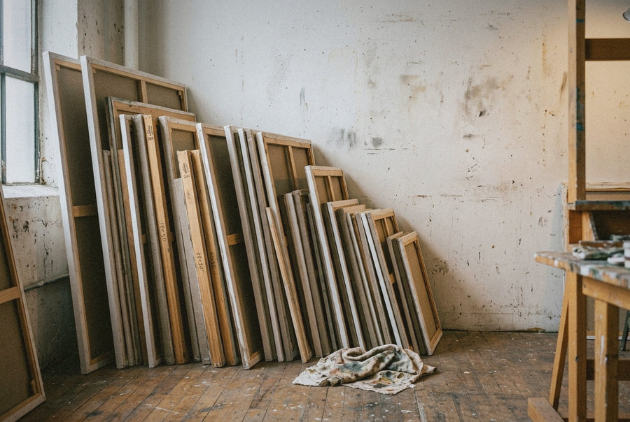 A stack of unfinished canvases leans face to the wall in the corner of the Brooklyn atelier, May afternoon light from the studio window