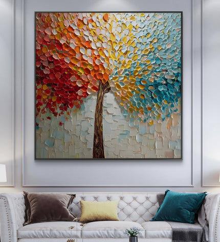 Colorful abstract tree painting on a wall above a sofa with decorative pillows.