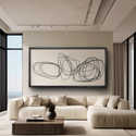 Modern living room with a beige sofa, abstract artwork, and large windows.